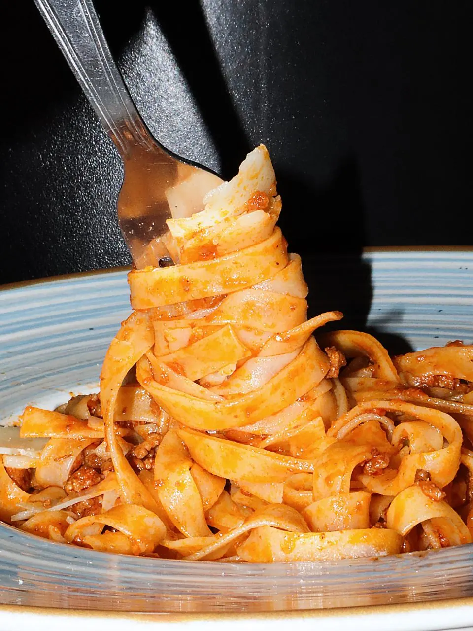 Tagliatelles fraîches au ragù enroulées sur une fourchette